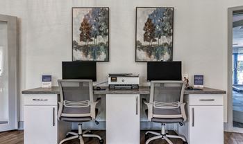 An office with three desks with computers and chairs